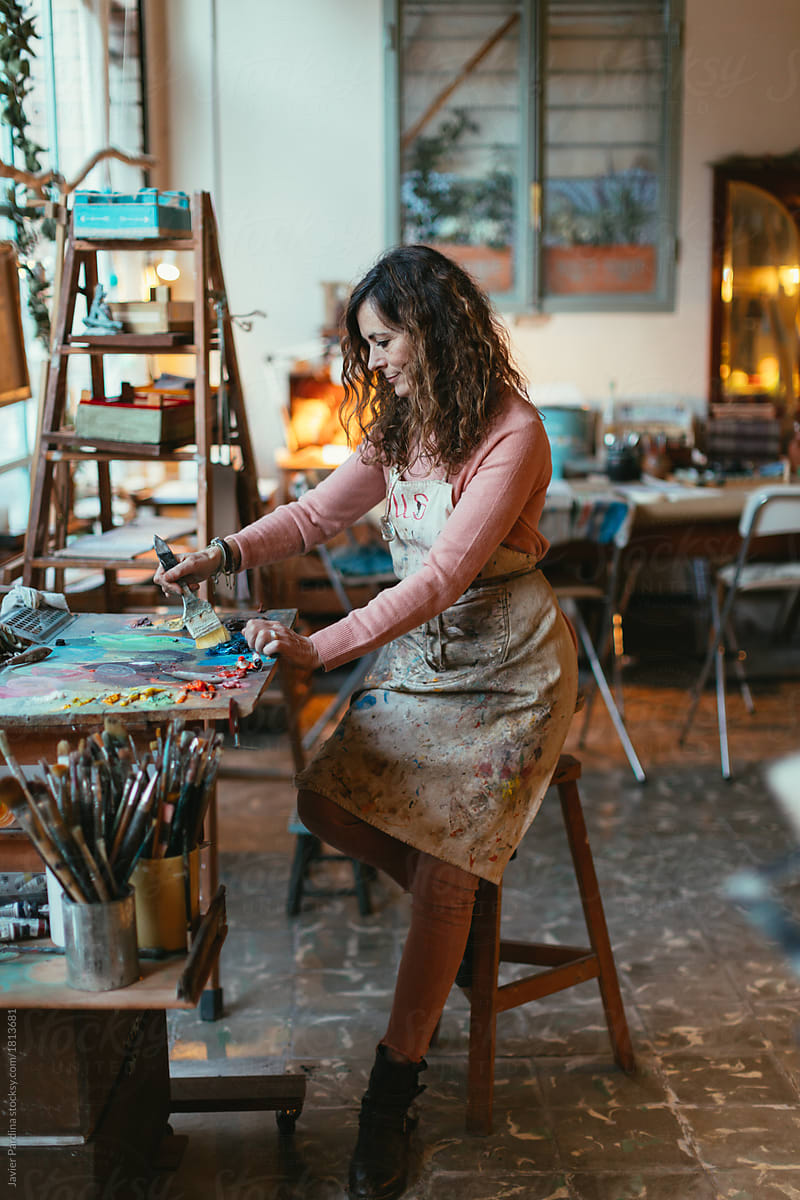 Portrait of senior female drawing artist in her art studio
