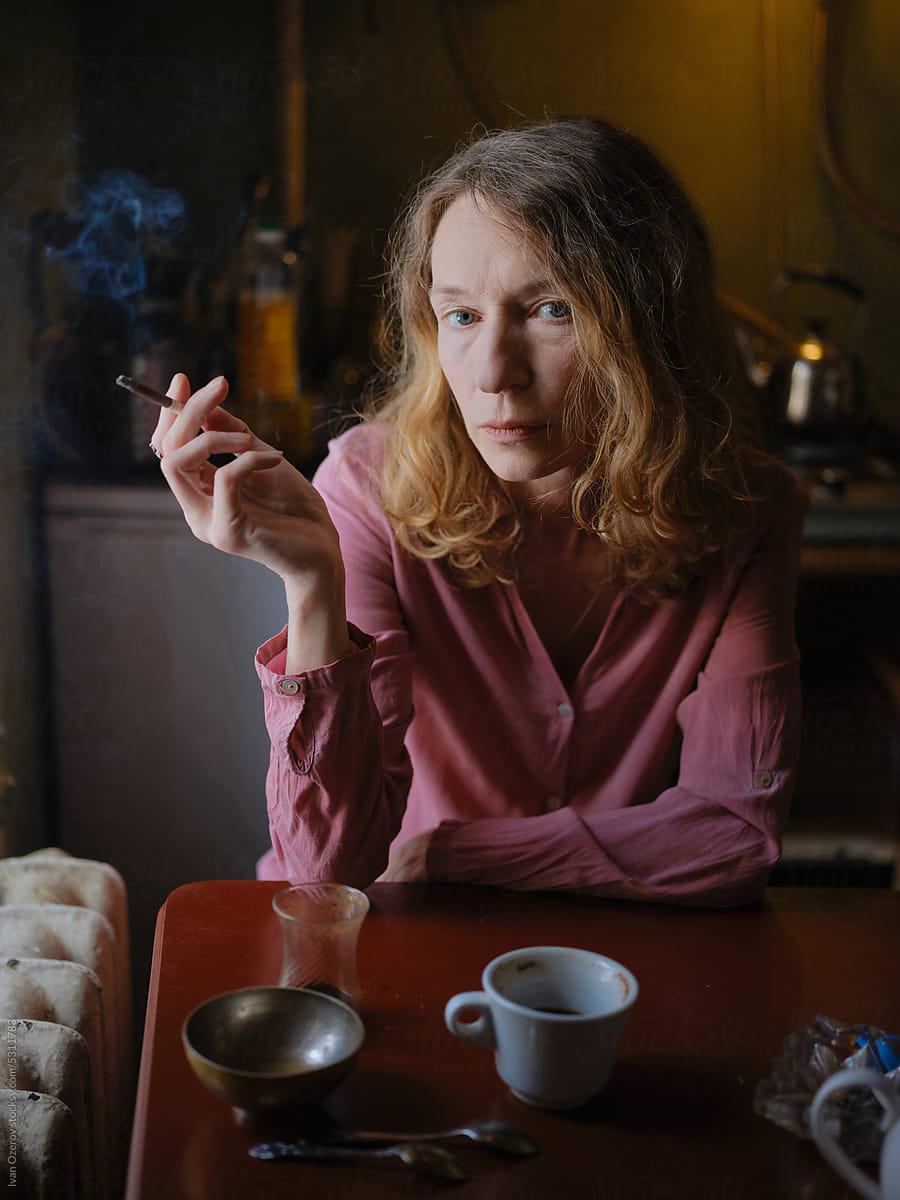 Mature Woman Smoking In Old Dark Kitchen