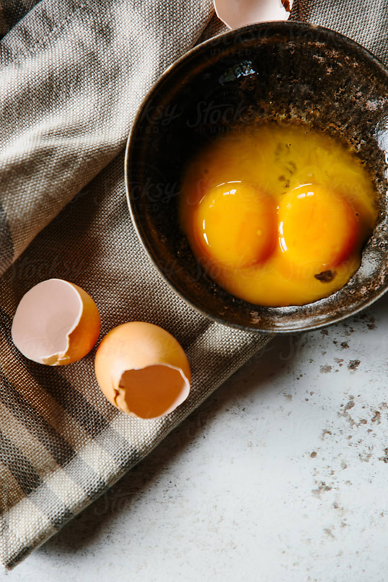 Egg yolks in a bowl with egg shells.