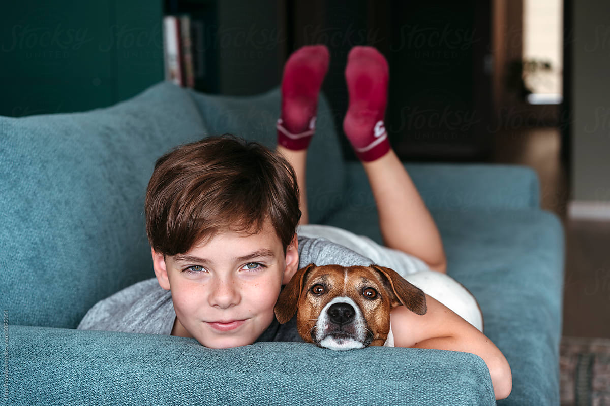 Boy and Dog Bonding on Blue Sofa