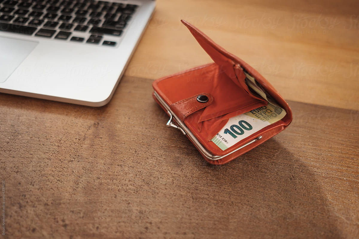Wallet With Euro Bills On The Desk Next To A Laptop
