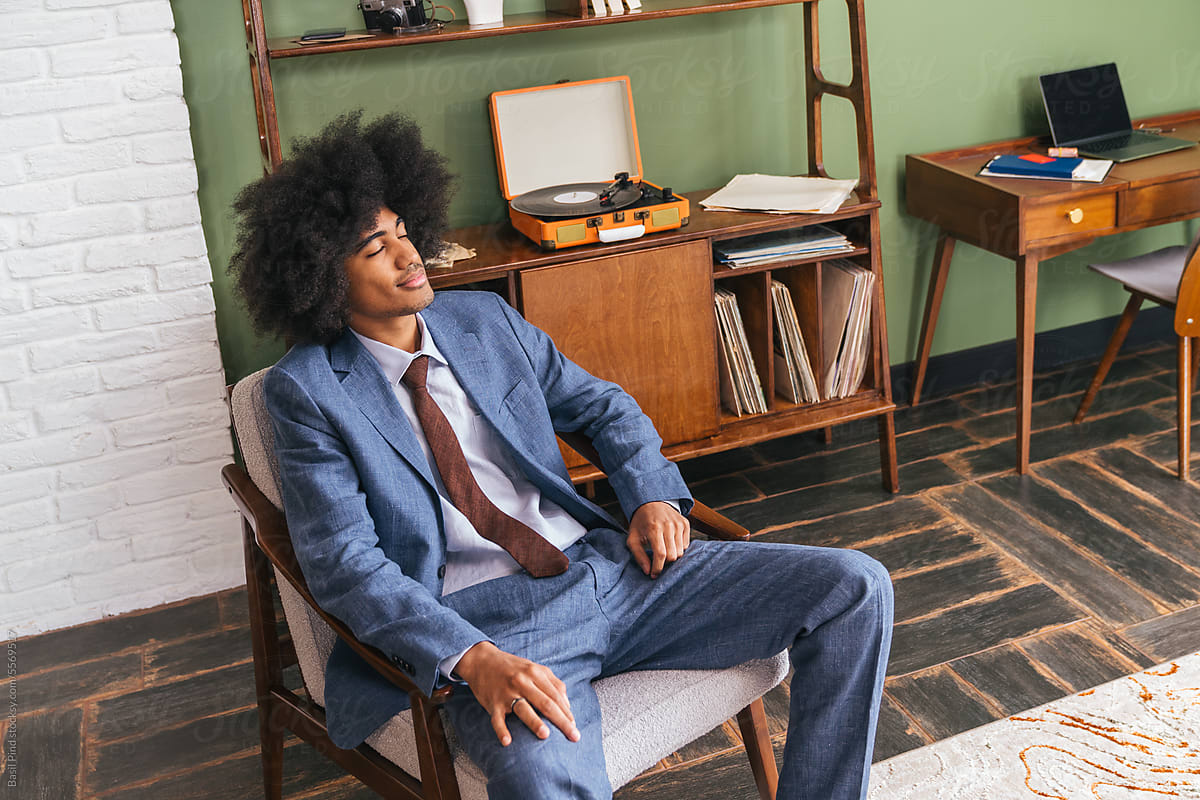 Young businessman with afro style hair listening music