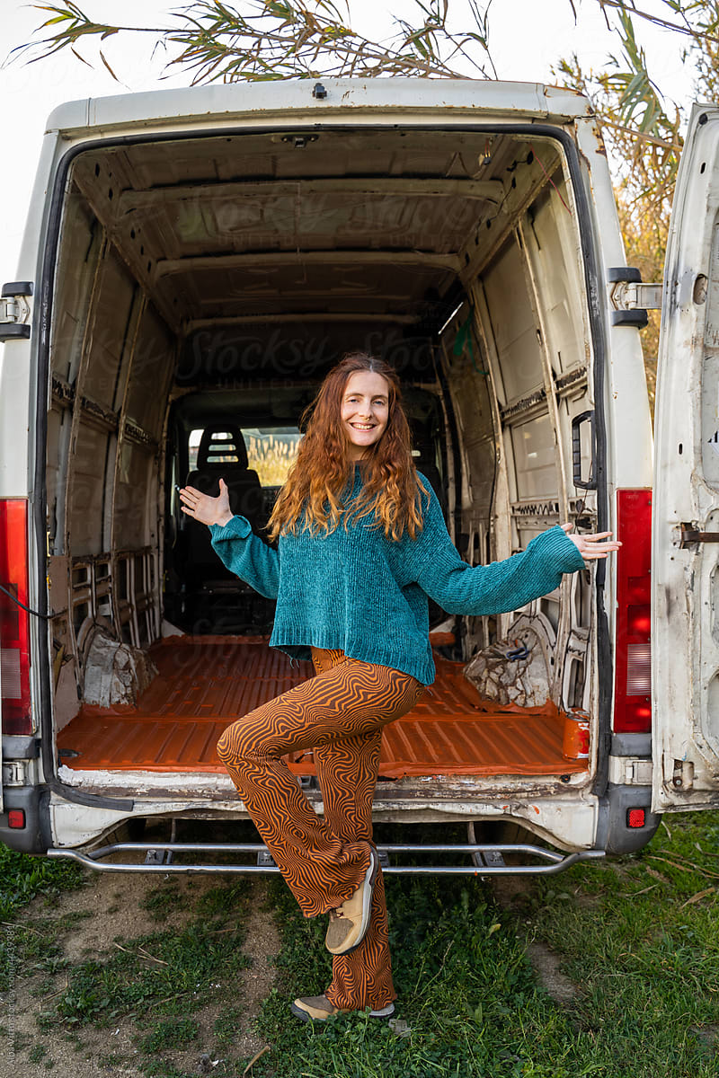 Portrait of woman posing next to old camper van ready to repair it