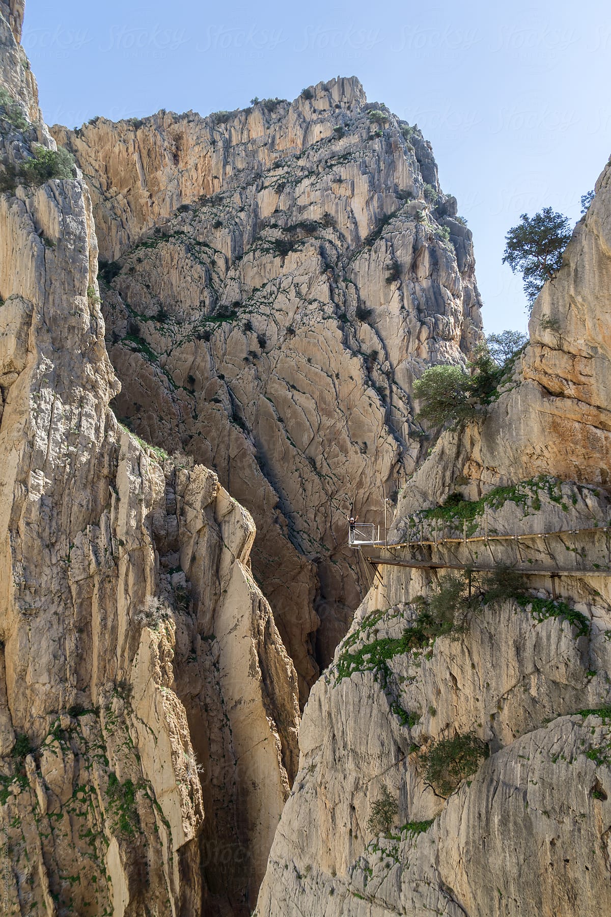 Woman saluting on the edge of a cliff in Caminito del Rey