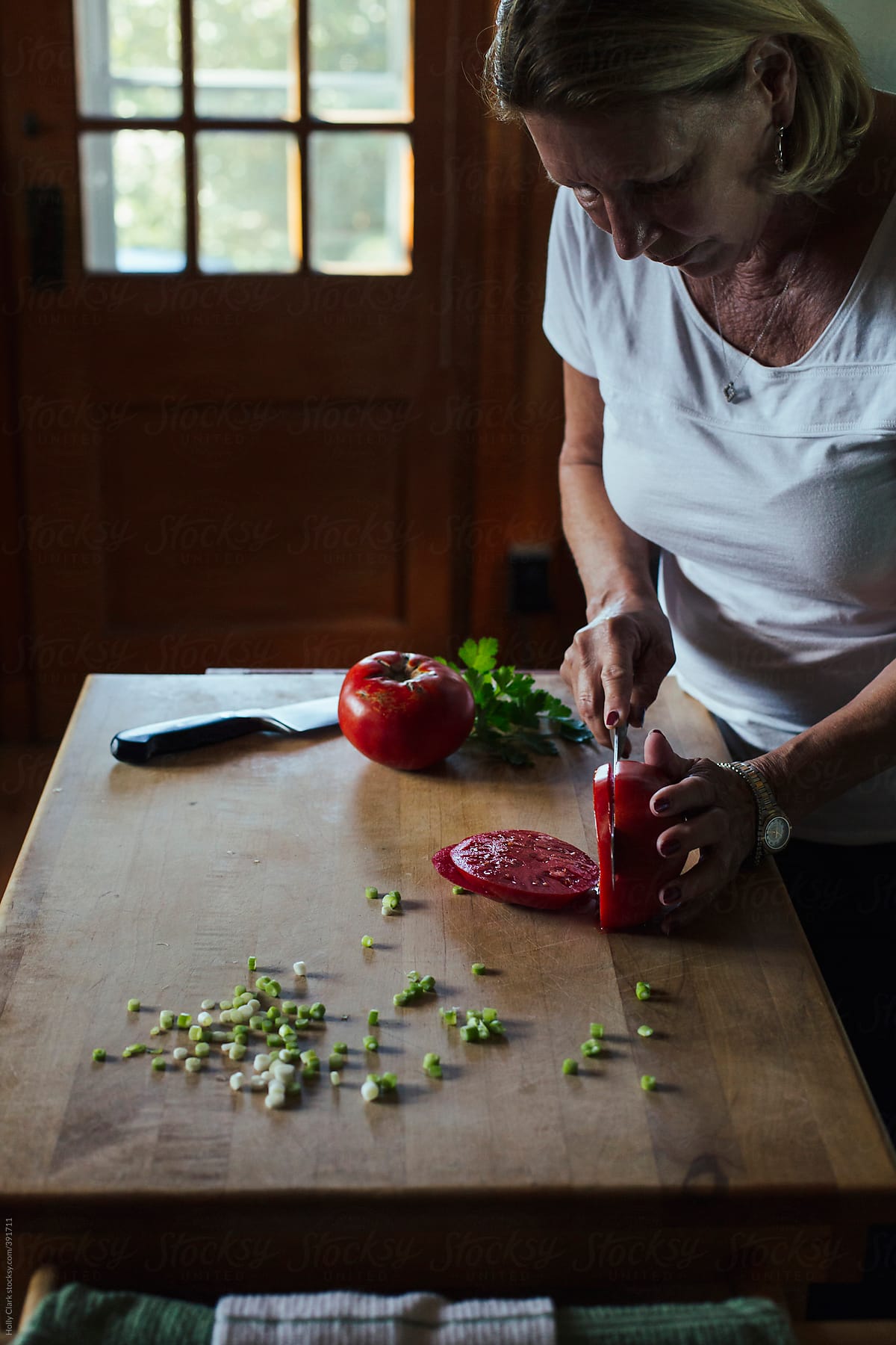 Woman slicing tomatoes in the kitchen.