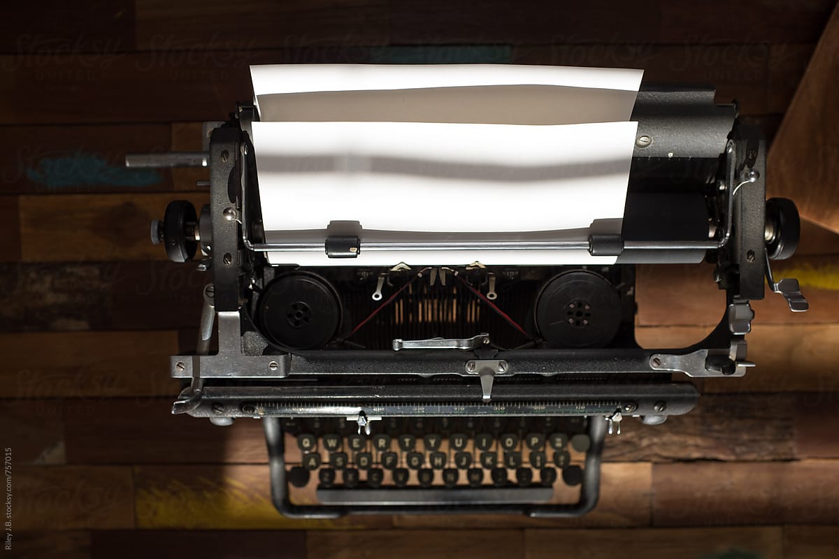 A vintage typewriter on a wooden table from above