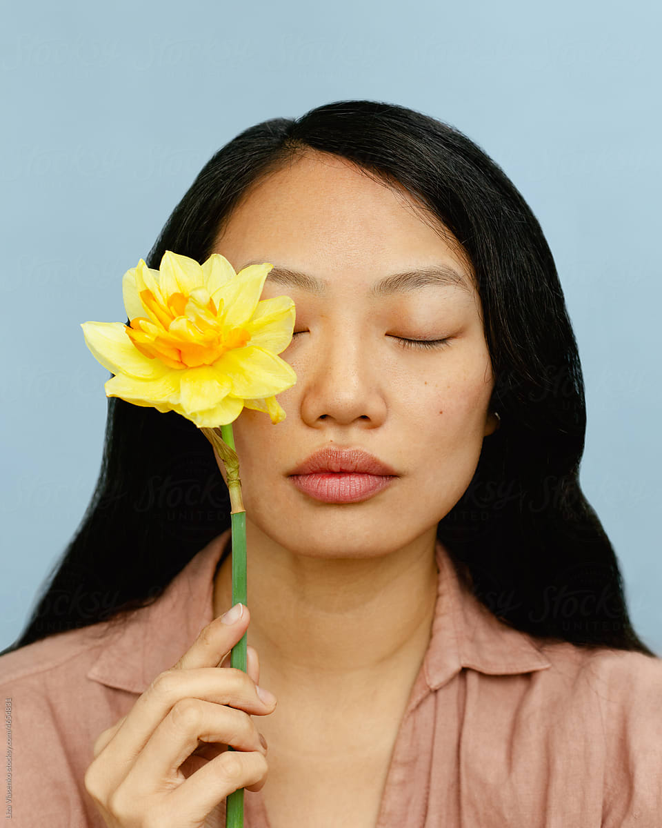 Asian woman with flower in blue background