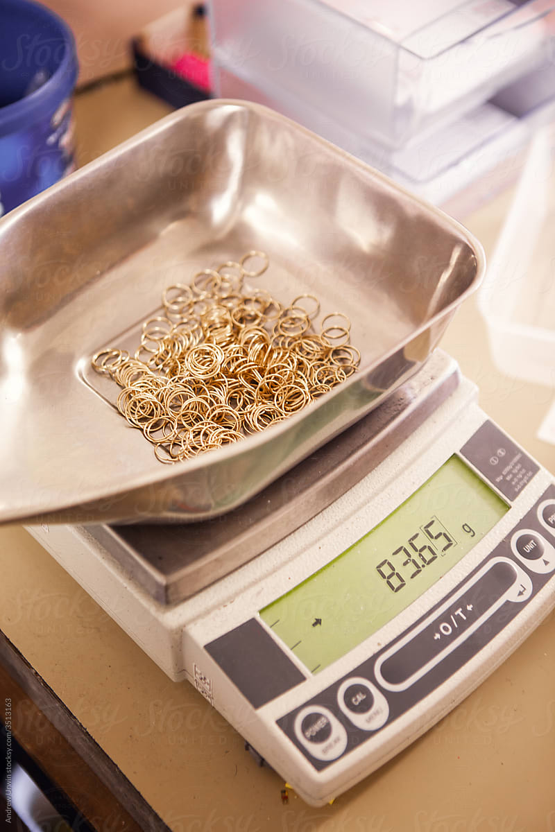 A pile of gold hoop earrings being weighed in a jewellery factory