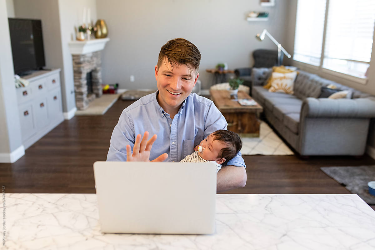 Man Waves On A Video Call While Holding A Baby