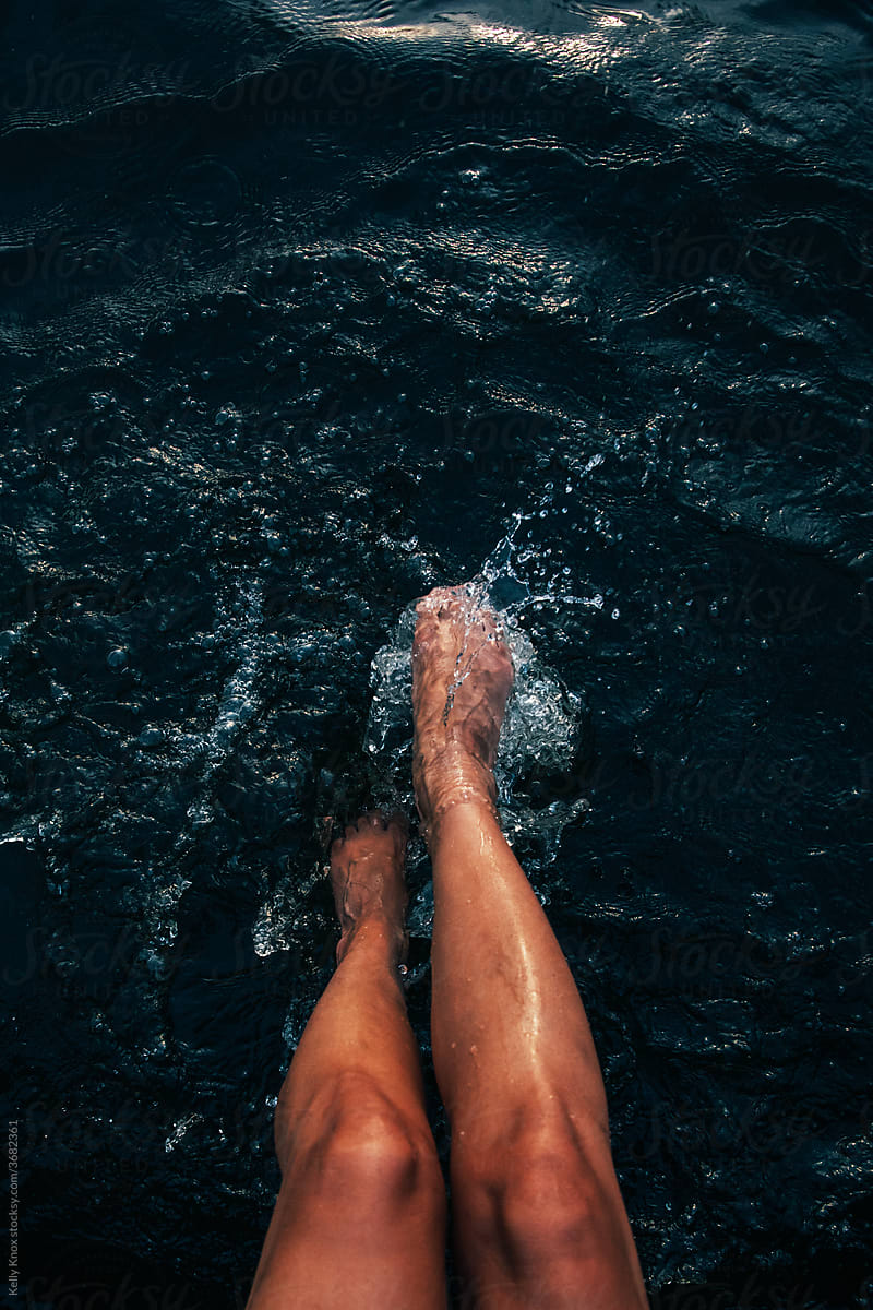 legs and feet of a woman splashing in water