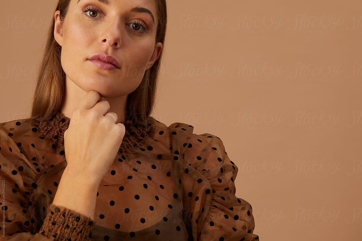 Confident woman against a brown background