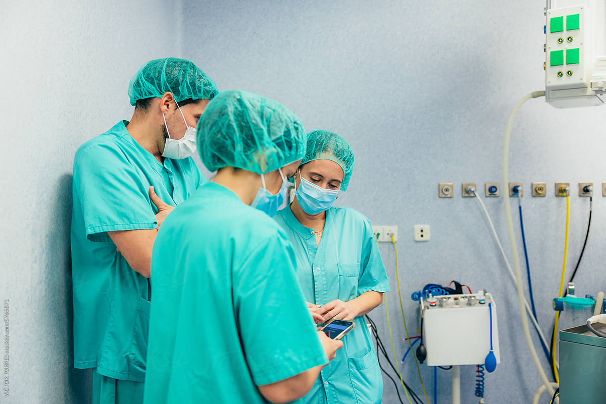 Medical team checking a cellphone in operating room