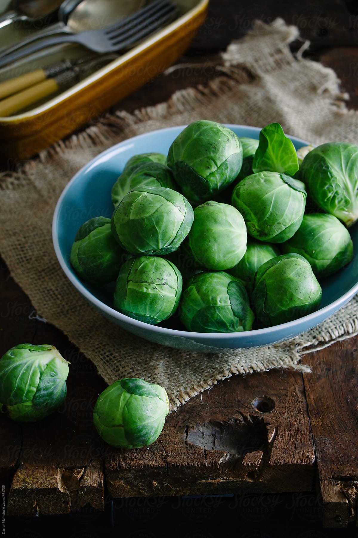 Brussels sprouts in a bowl on a table ready to be prepared for cooking.