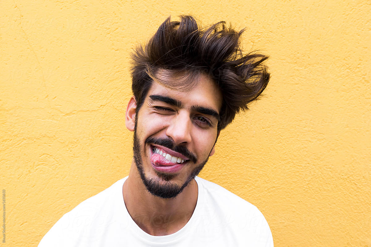 Portrait Of A Handsome Young Man With Goatee Making Funny Face And Looking  At Camera