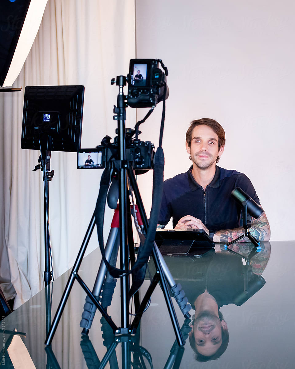 Millennial freelance journalist records video on cameras in a studio