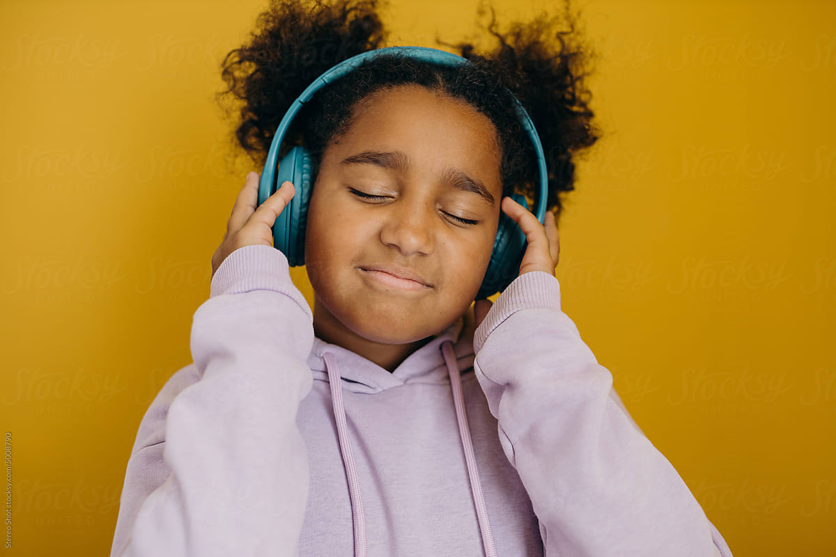 Smiling black girl listening to music in studio