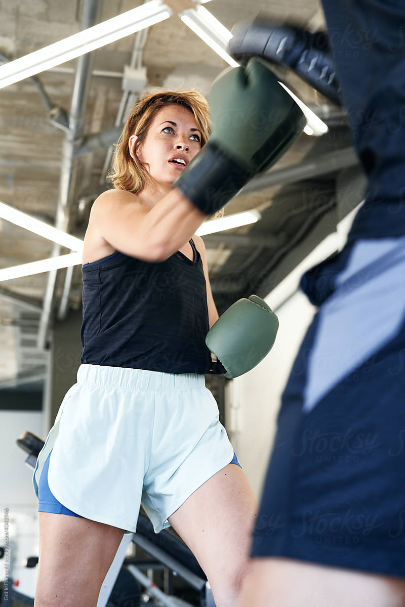 Female boxer training with instructor in gym