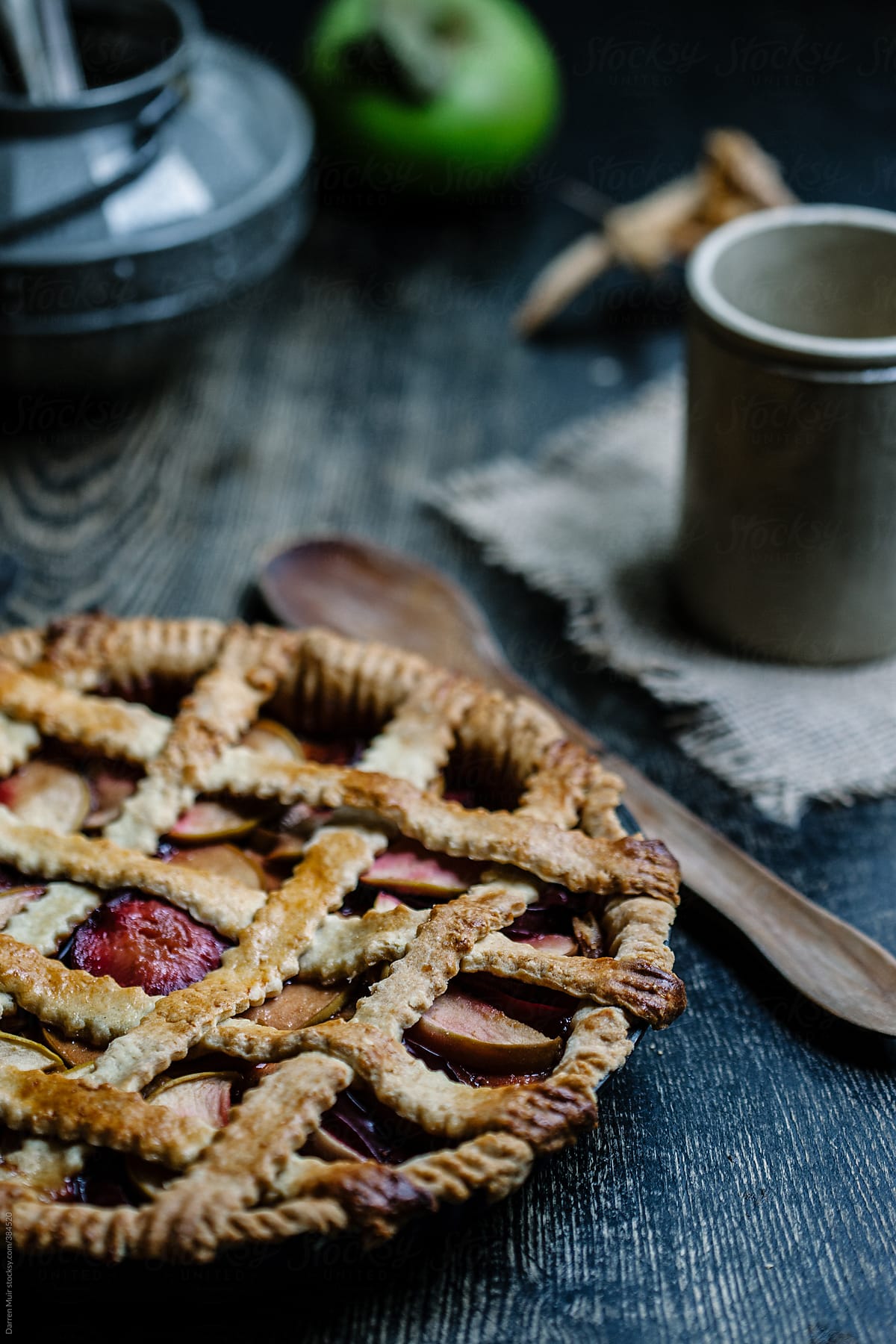 Homemade apple and plum pie on table.