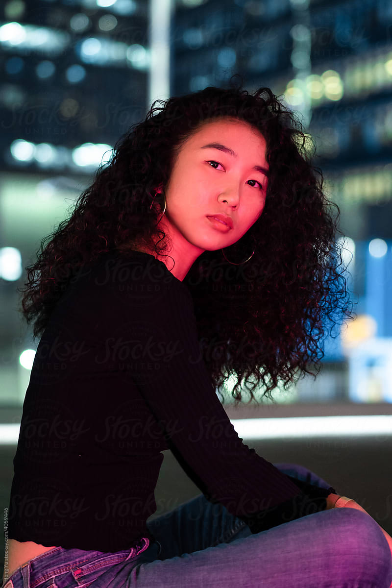 Woman sitting in front of city lights at night