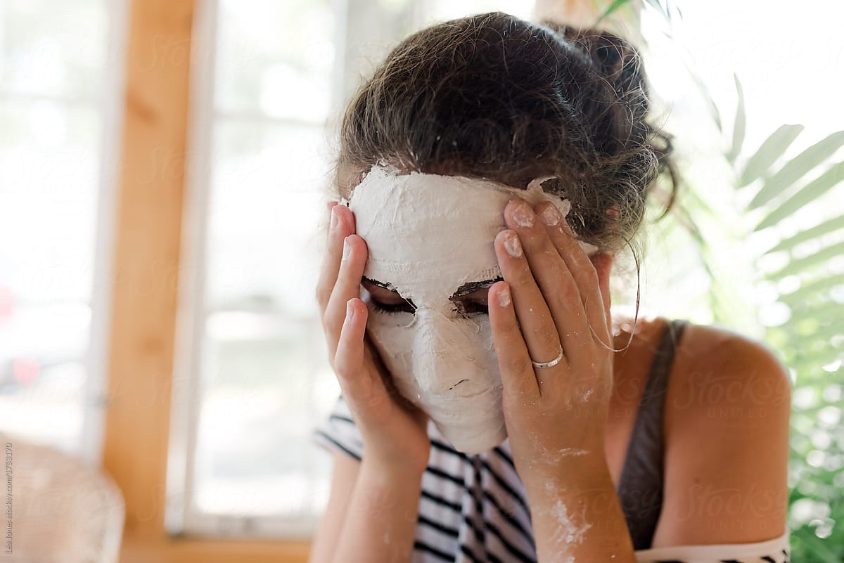 teen removing plaster mask