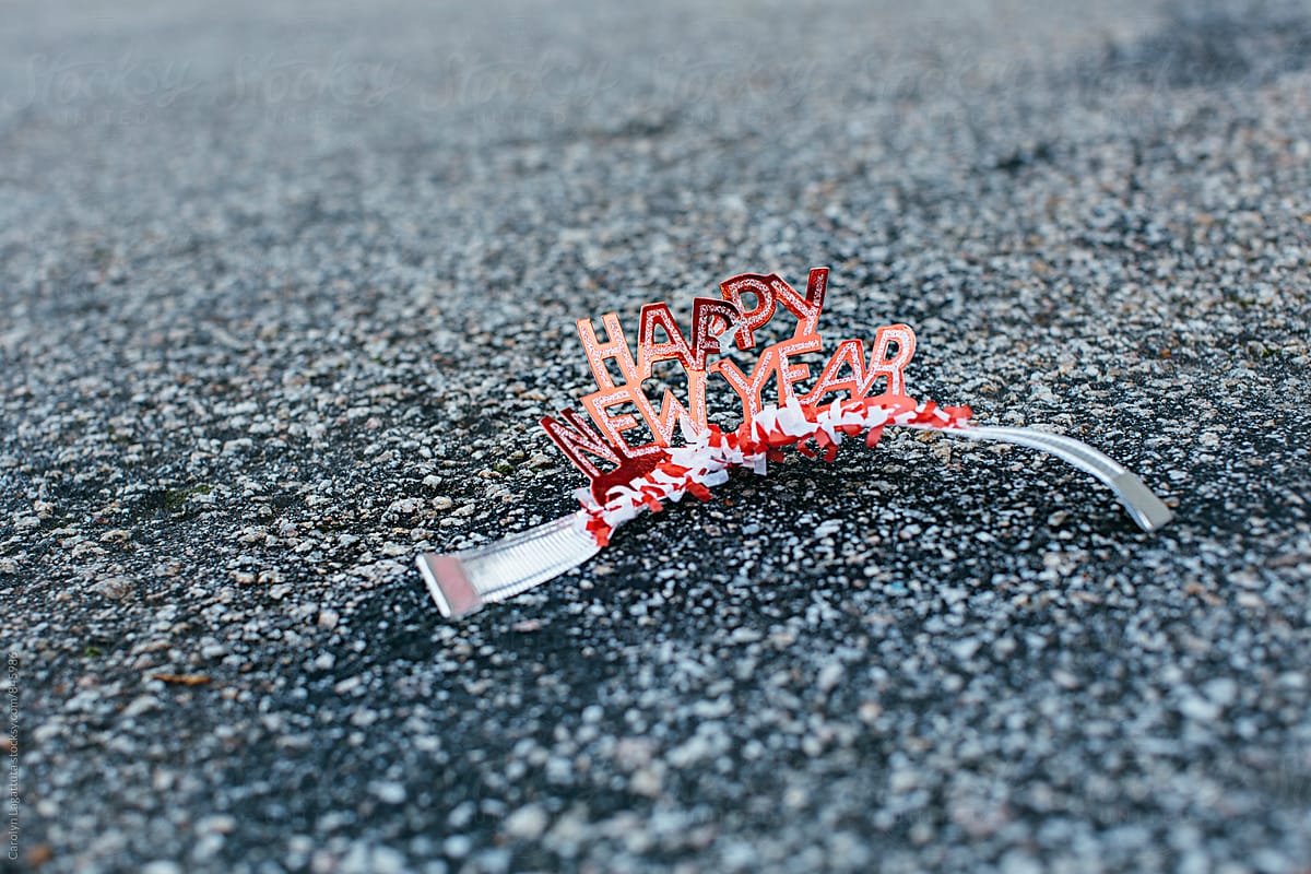 Crumpled Happy New Year headband on the ground - after the party