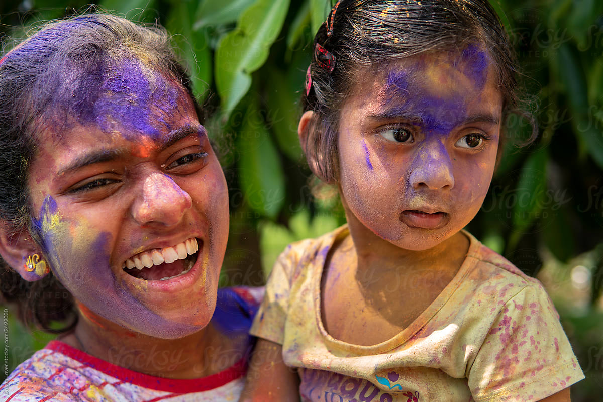 Sisters playing Holi with colorful powders
