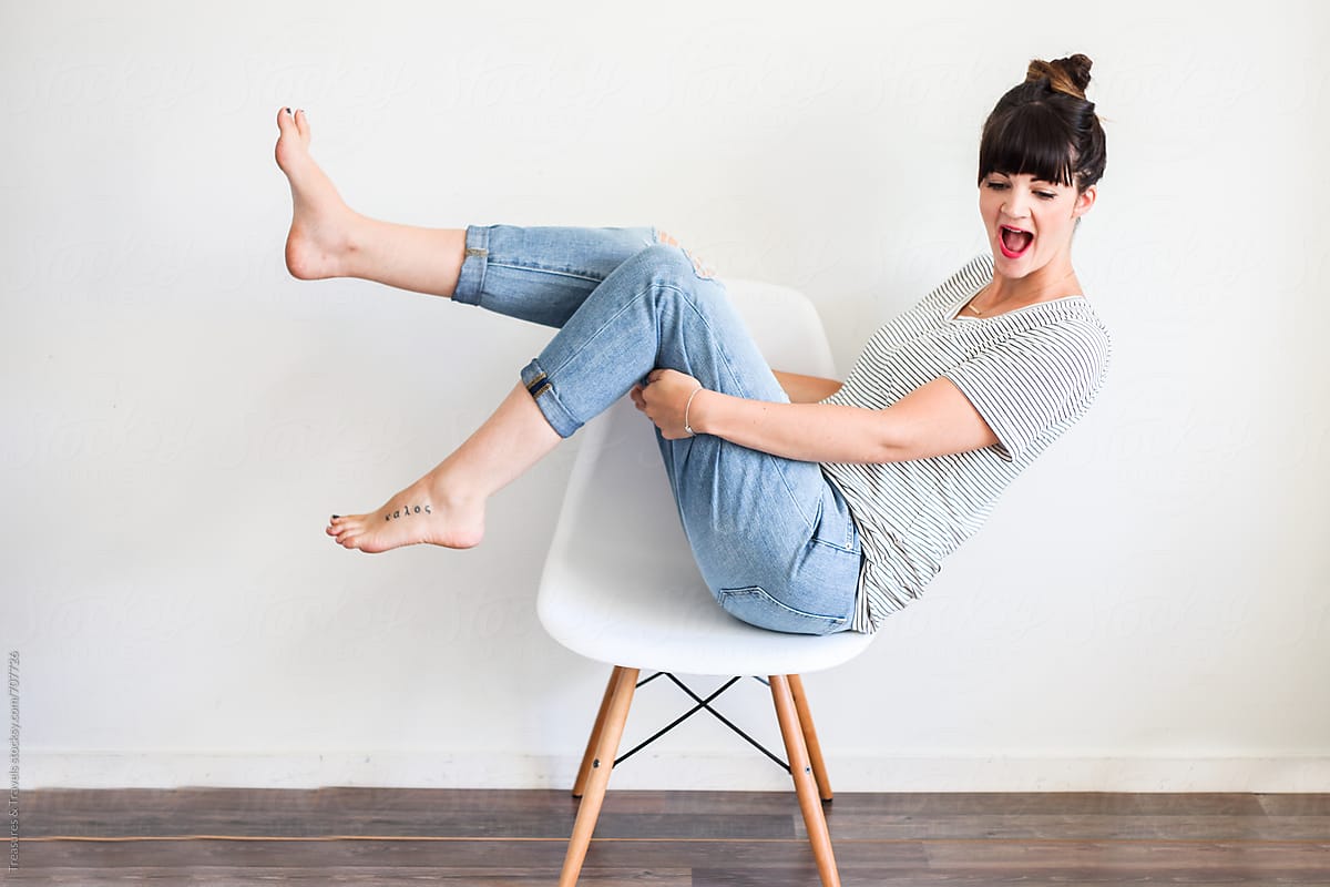 woman sitting on a chair with feet in the air
