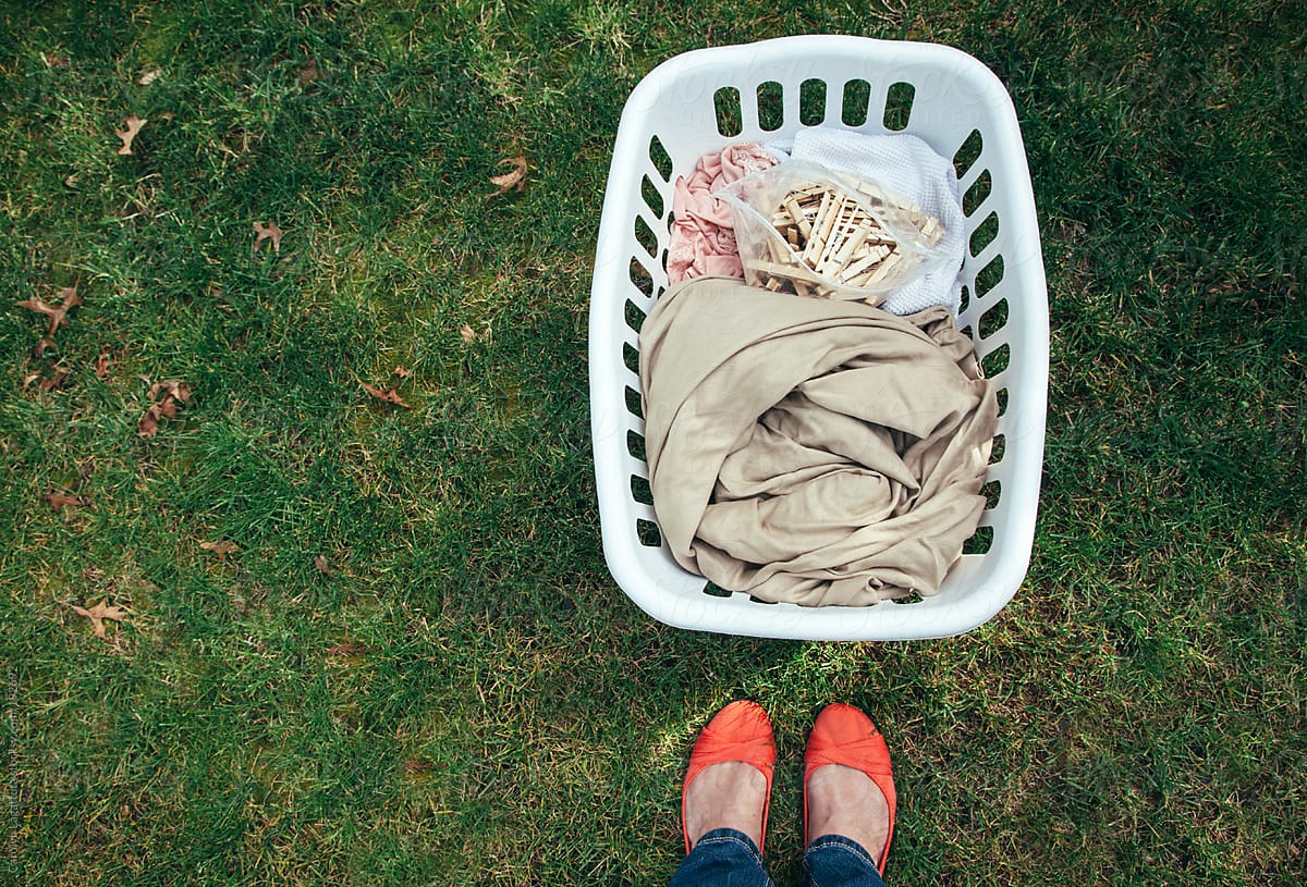Standing Outside Above A Freshly Dried Basket Of Laundry And Clothes Pins  by Stocksy Contributor Carolyn Lagattuta - Stocksy