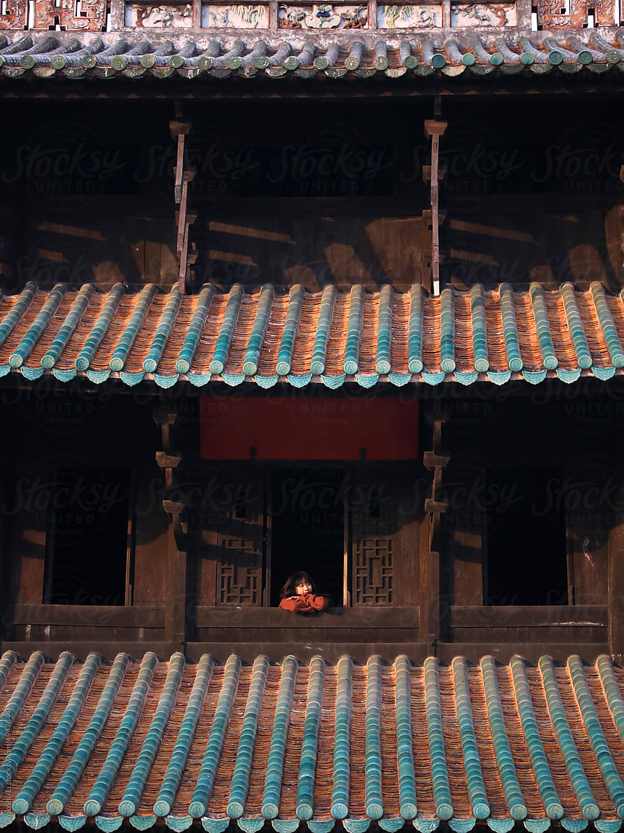 Asian lady in the attic of an ancient Chinese building