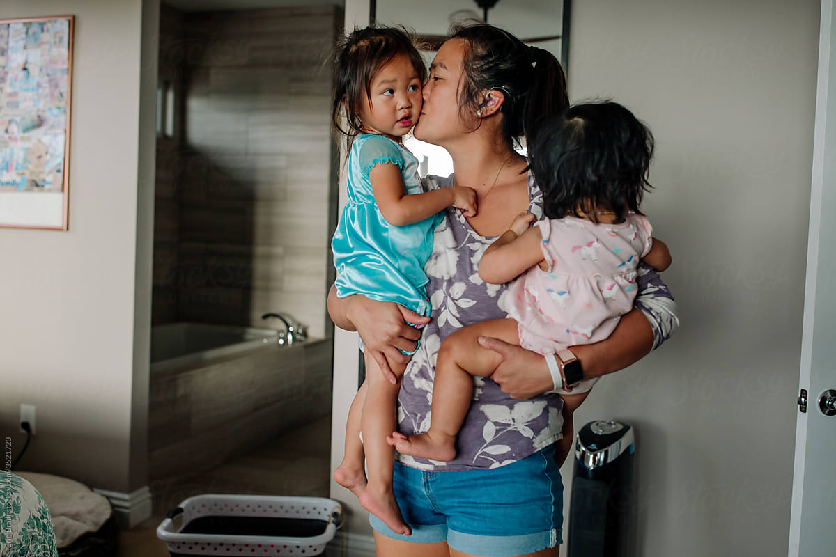 Asian mom holding young daughters