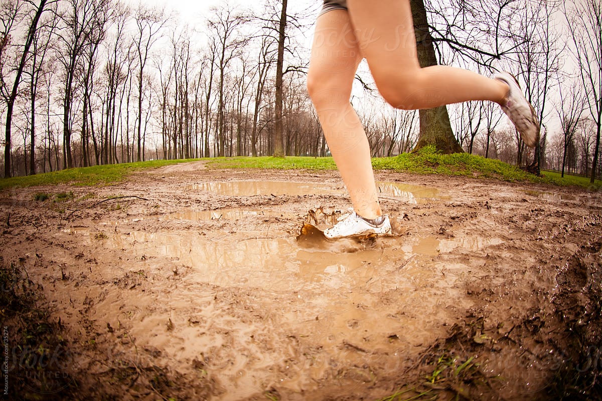 Woman jogging in the park on a rainy spring day.