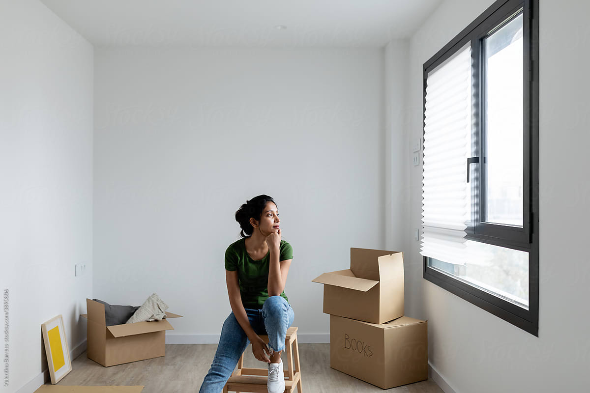 Indian woman sitting on a small ladder at new apartment