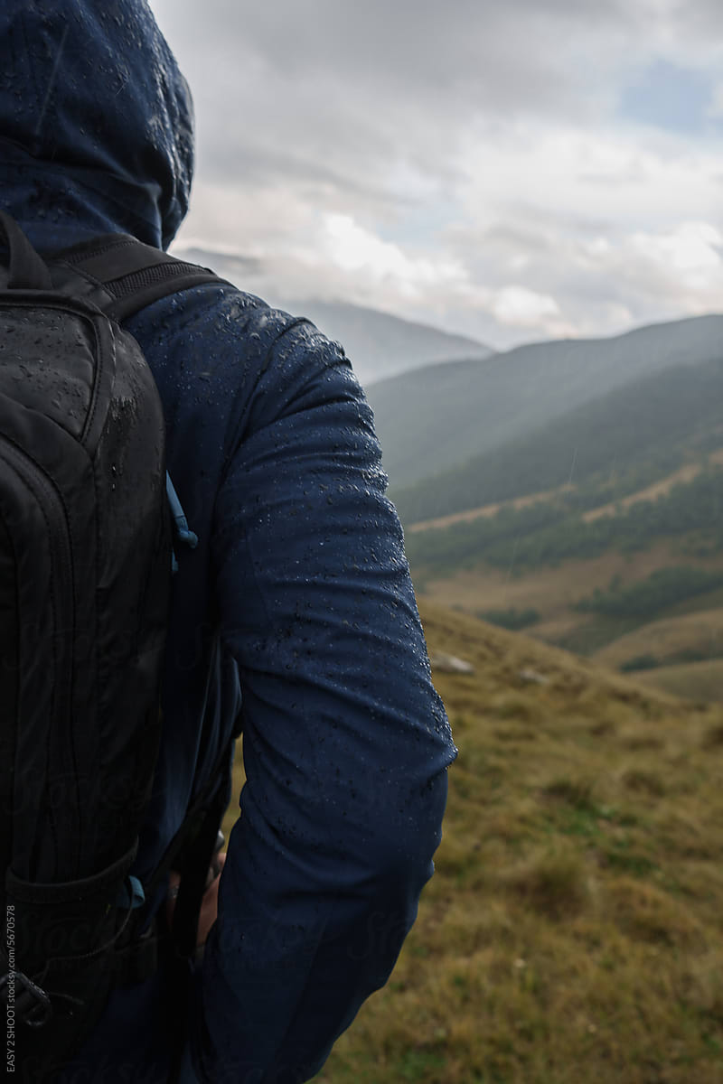 Mountain Hiker Wears Backpack at Stunning Landscape with Dramatic Sky