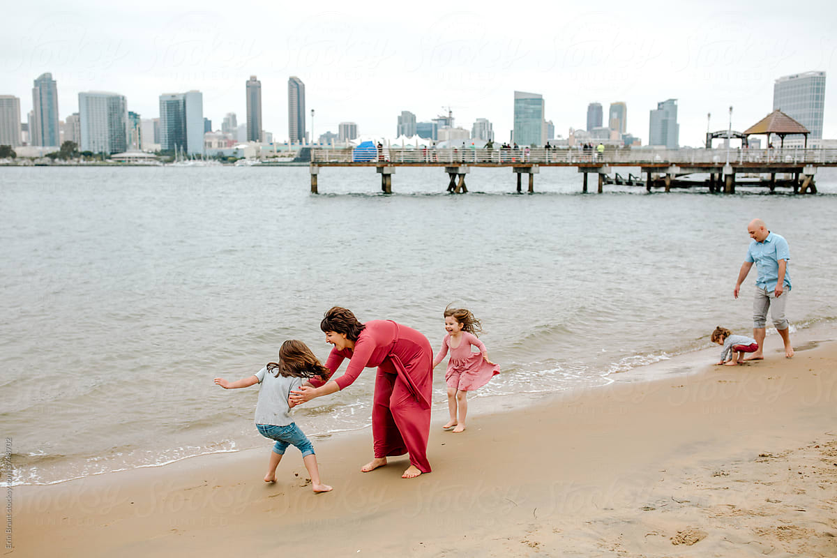 Barefoot family on beach near ferry landing