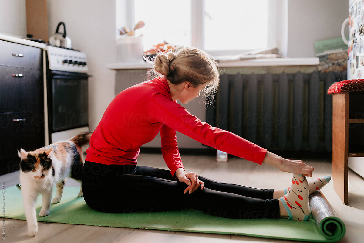 Girl Stretching with pet at home.