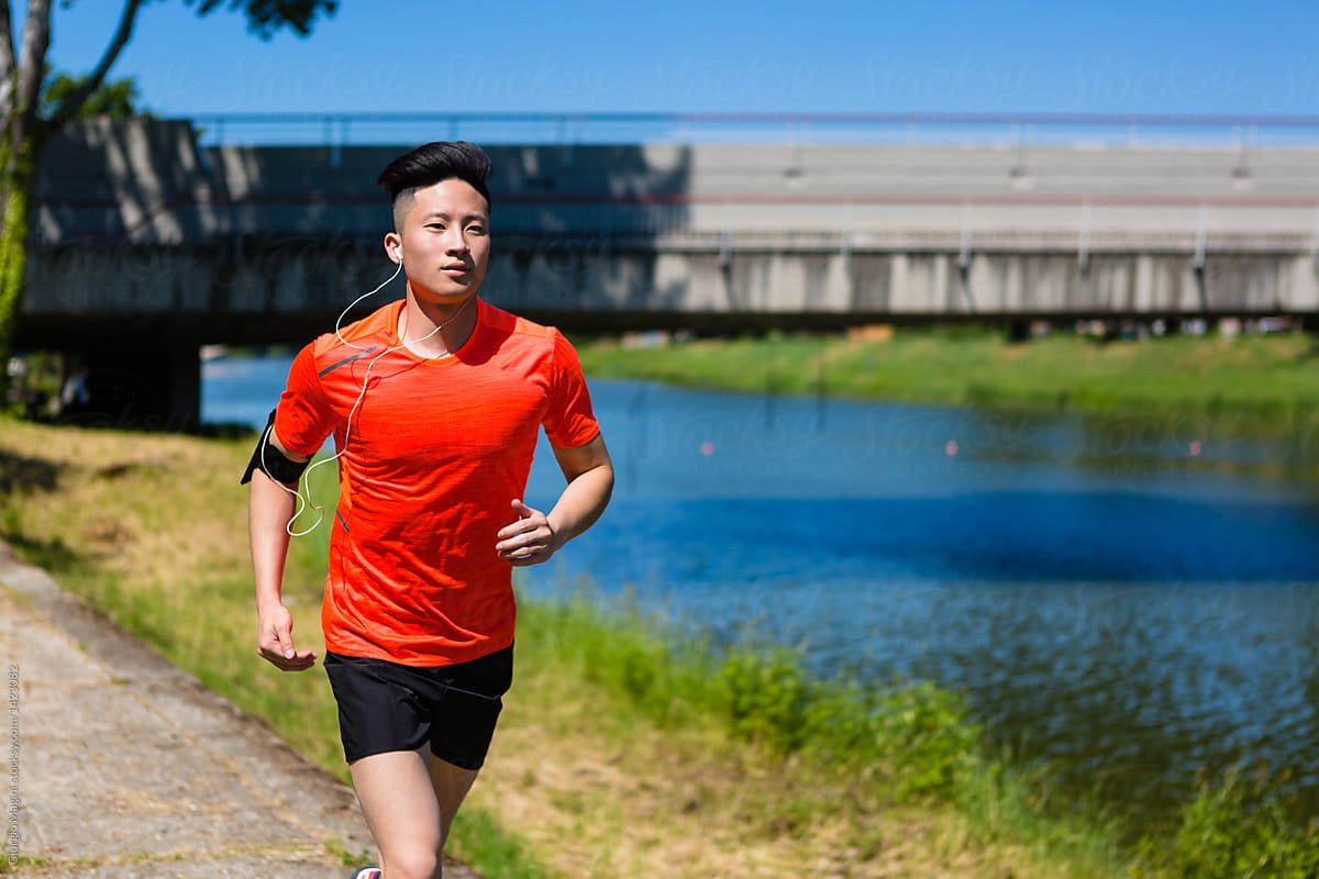 Young Chinese Man Running in the City near a River