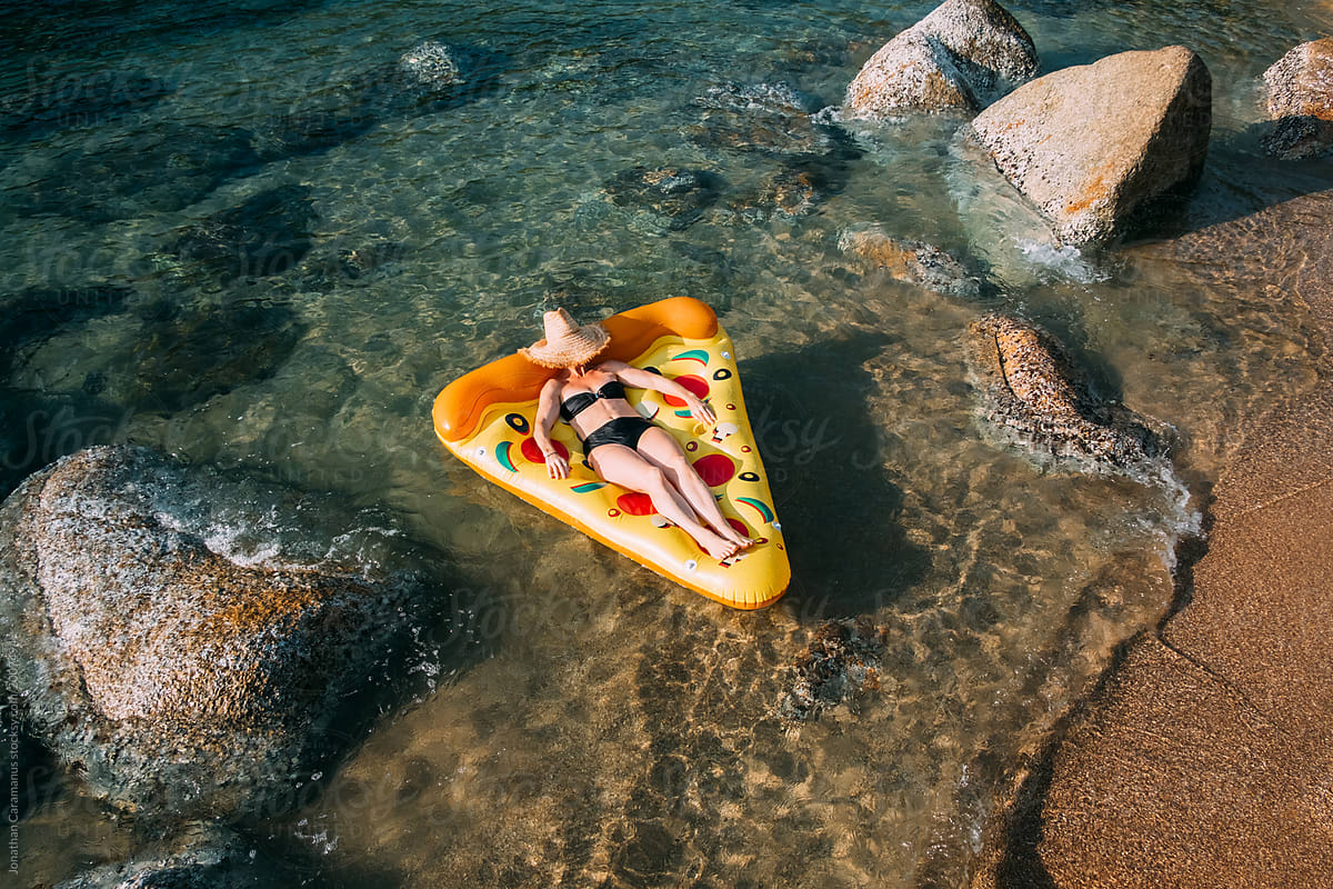 Woman floating on inflatable pizza lilo float
