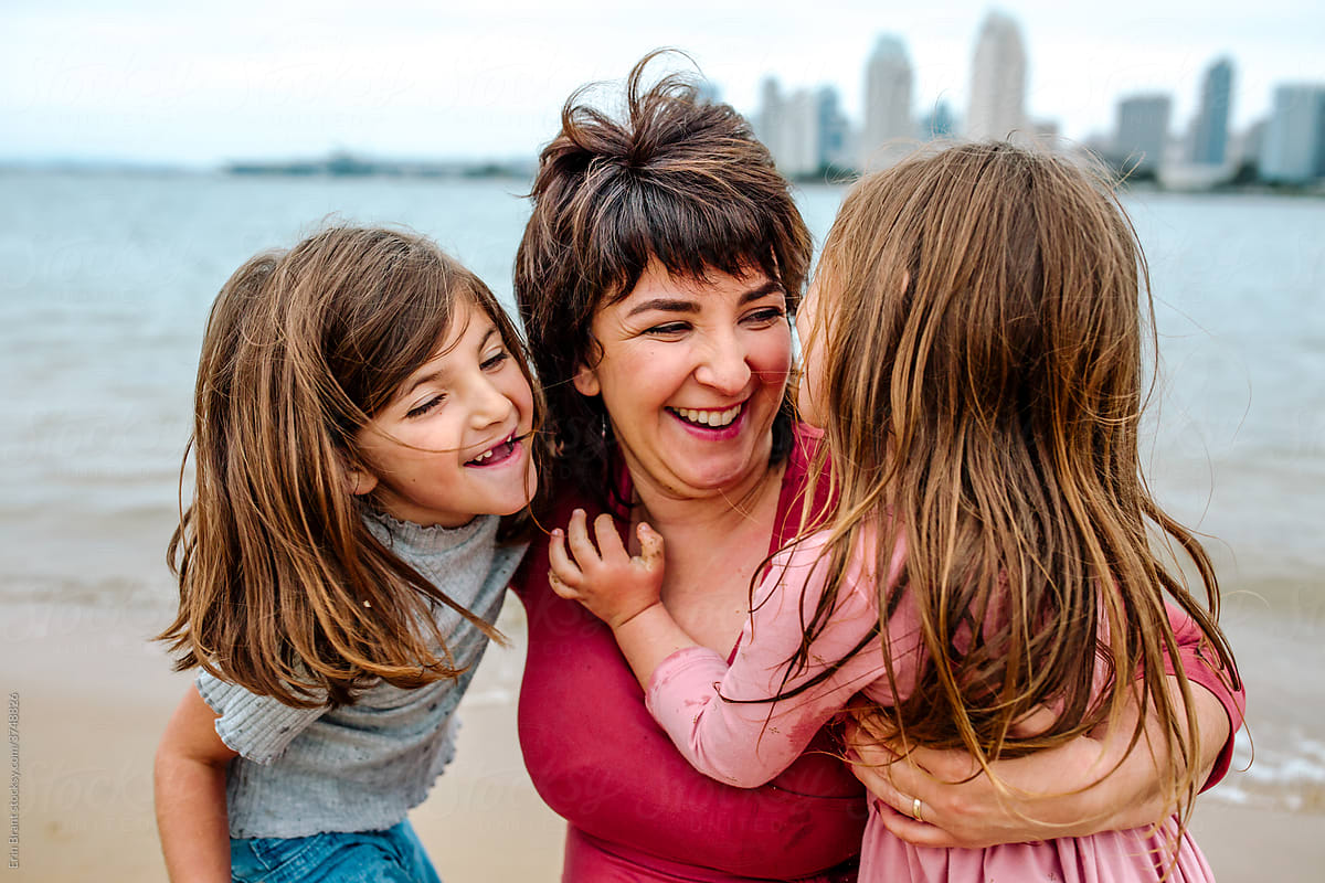 Mother laughing with daughters at beach