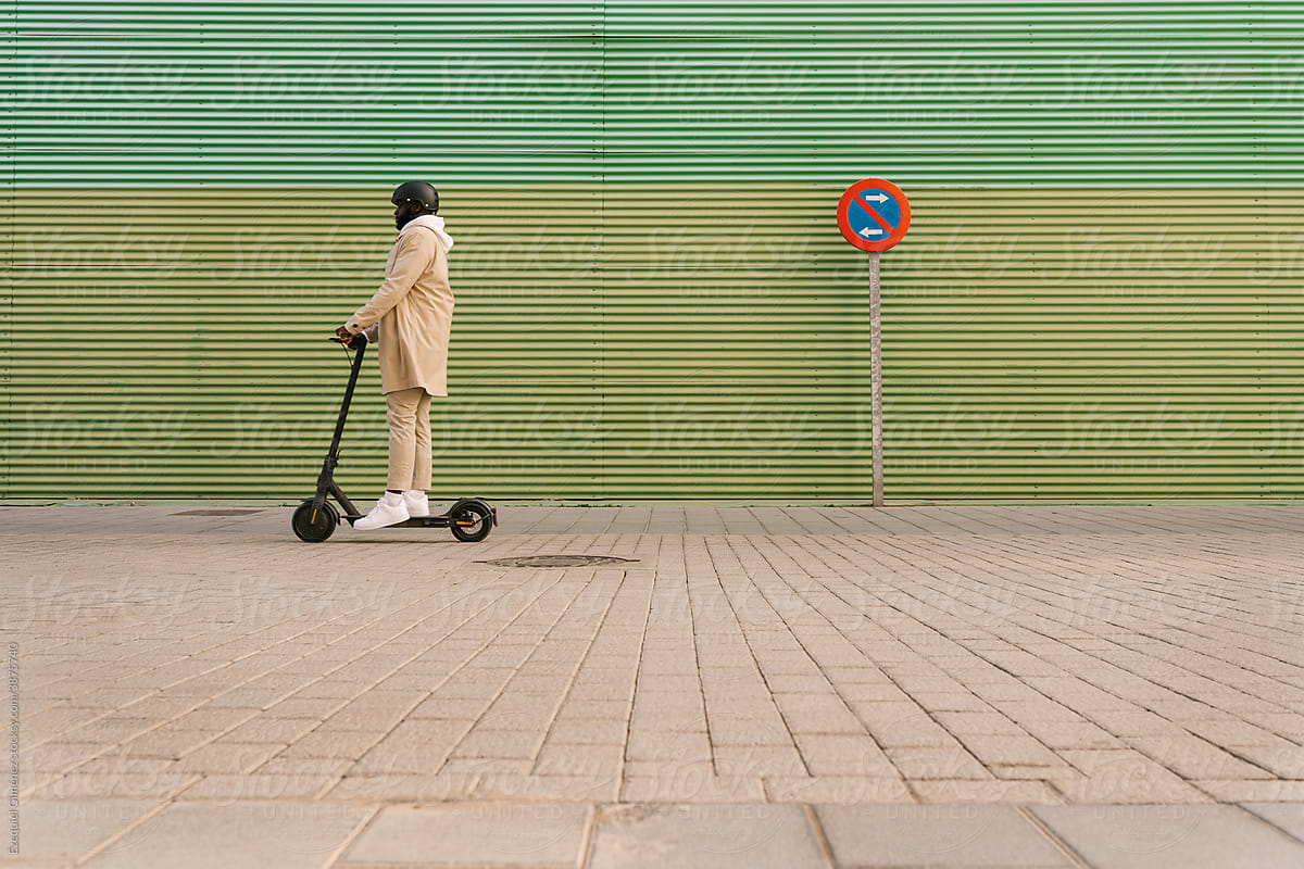 Black man with helmet on an electric scooter