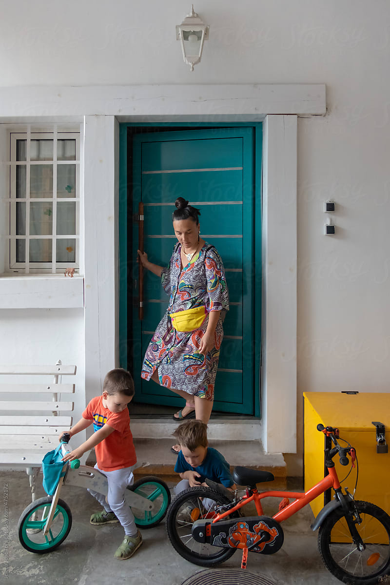 Mother and two kids in front of their home door