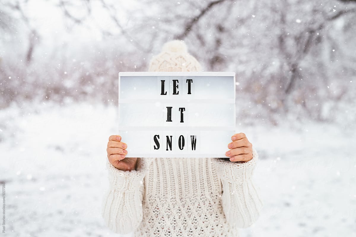 Woman holding let it snow message on light box