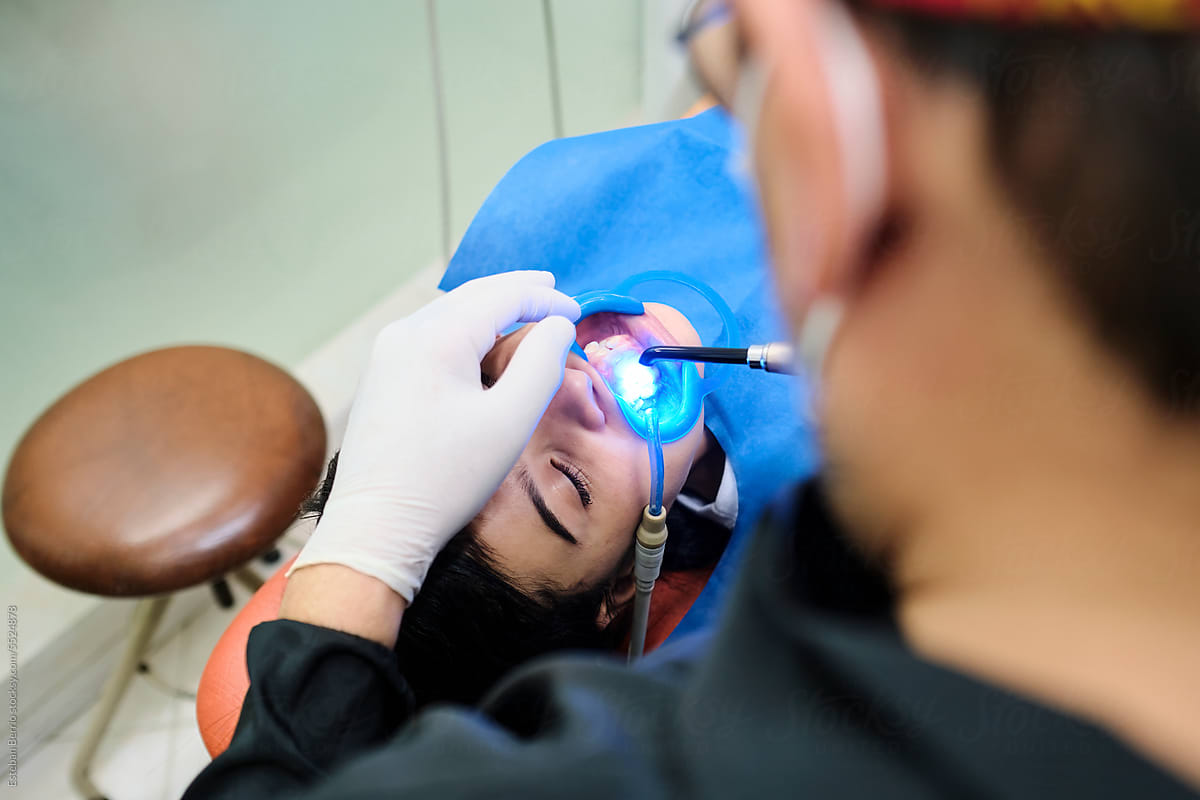 Dentist using the cold light lamp on a patient