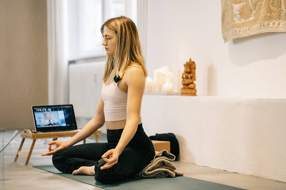 Female Yoga Instructor Meditating During Online Video Class