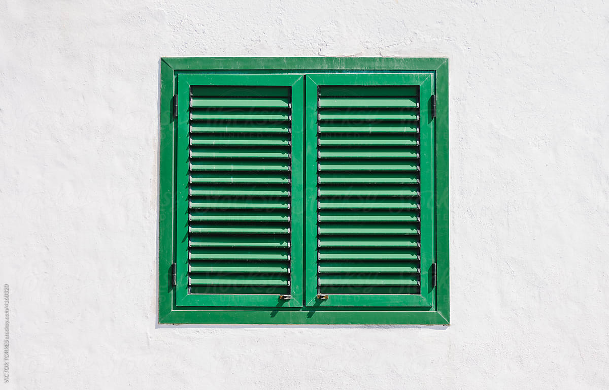 White wall with green wooden window