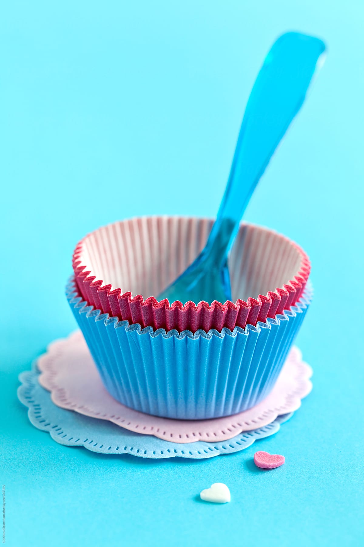 still life of pink and blue baking tin on blue background with spoon