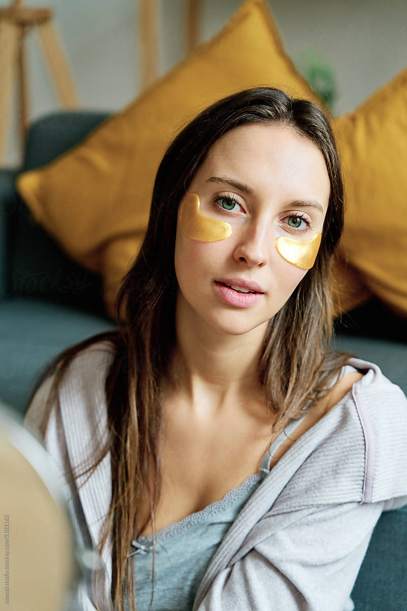 Woman with eye patches to reduce swelling.