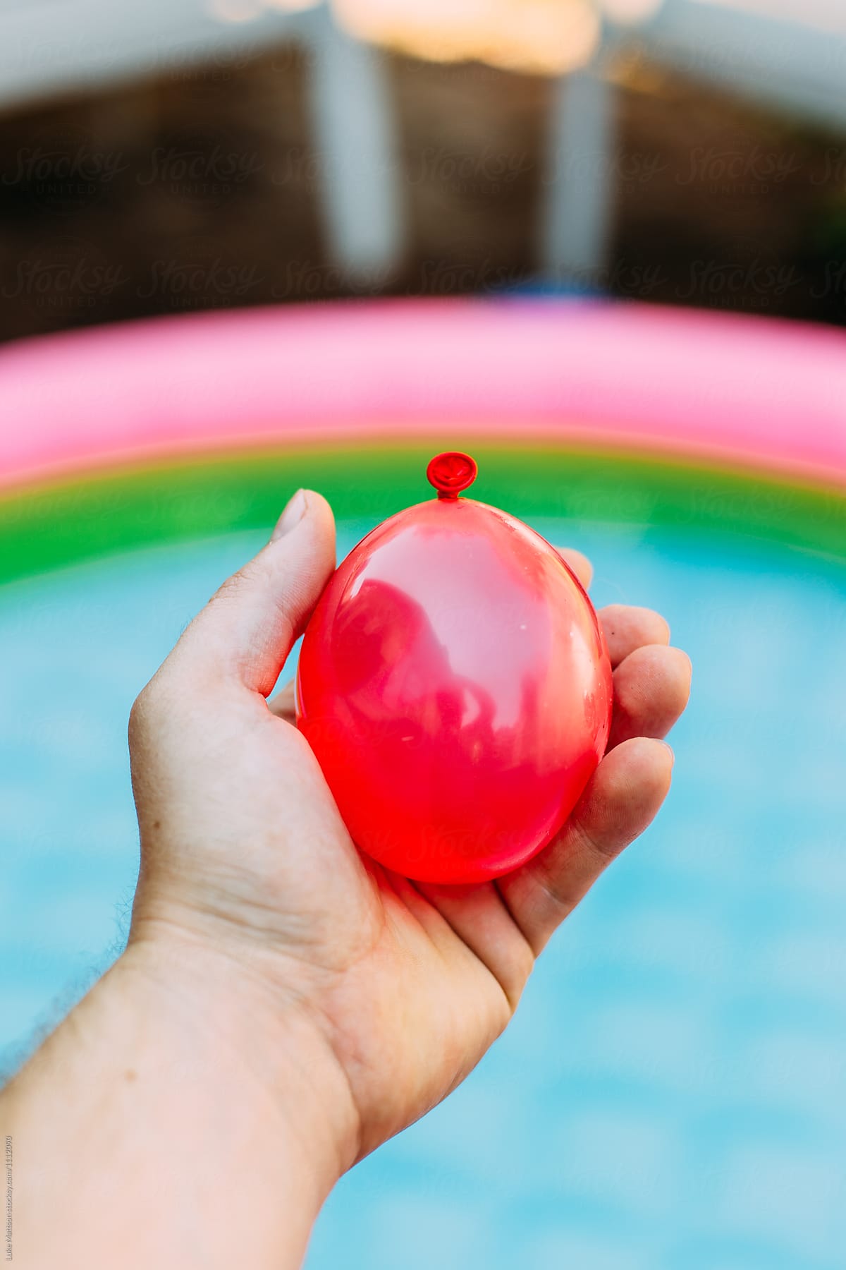 Colorful Red Water Balloon In Palm Of Hand