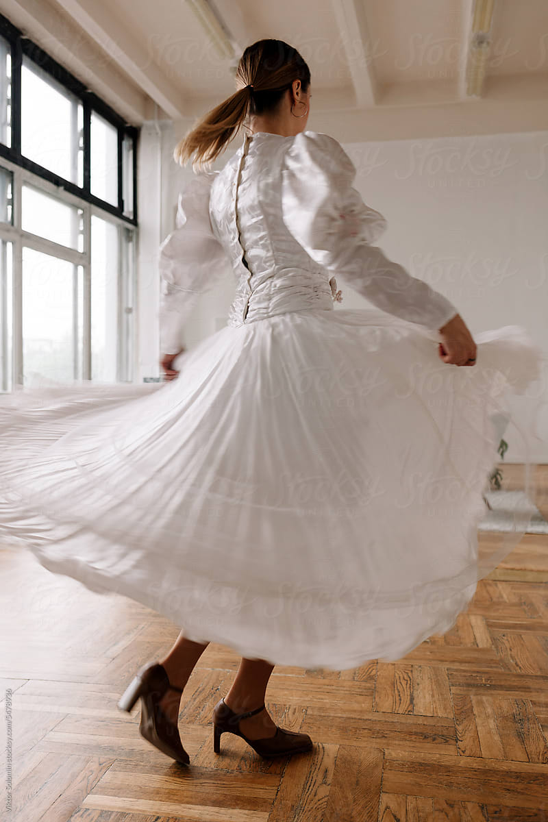 Elegant bride in white dress dancing