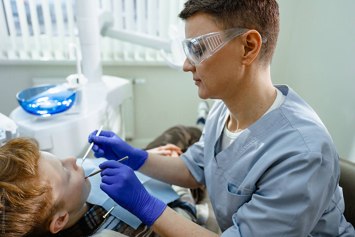 A dentist treats a child\'s teeth