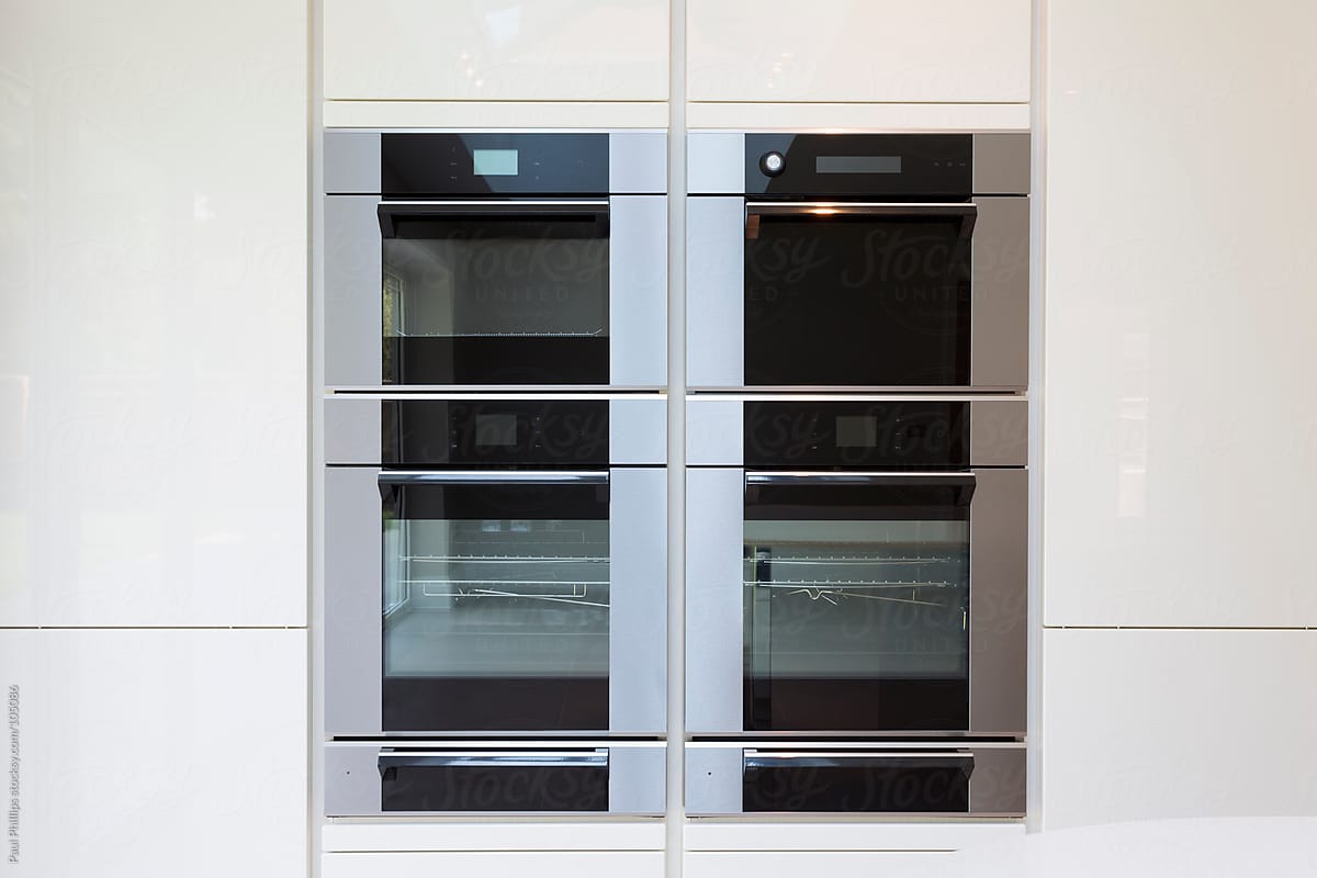 Modern integrated cooking unit set in white cabinets